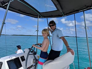 Brian and son at the helm during their bareboat catamaran in the Bahamas
