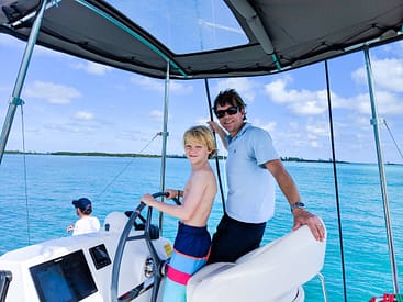 Brian and son steering a bareboat catamaran charter